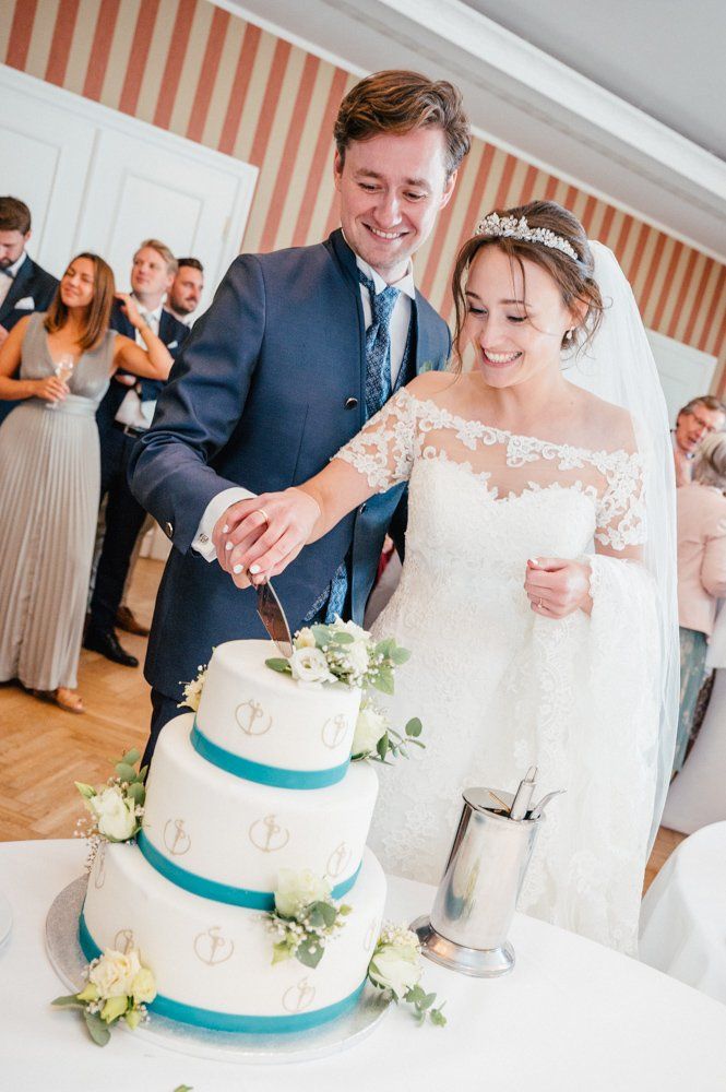 Anschnitt Hochzeitstorte durch Brautpaar