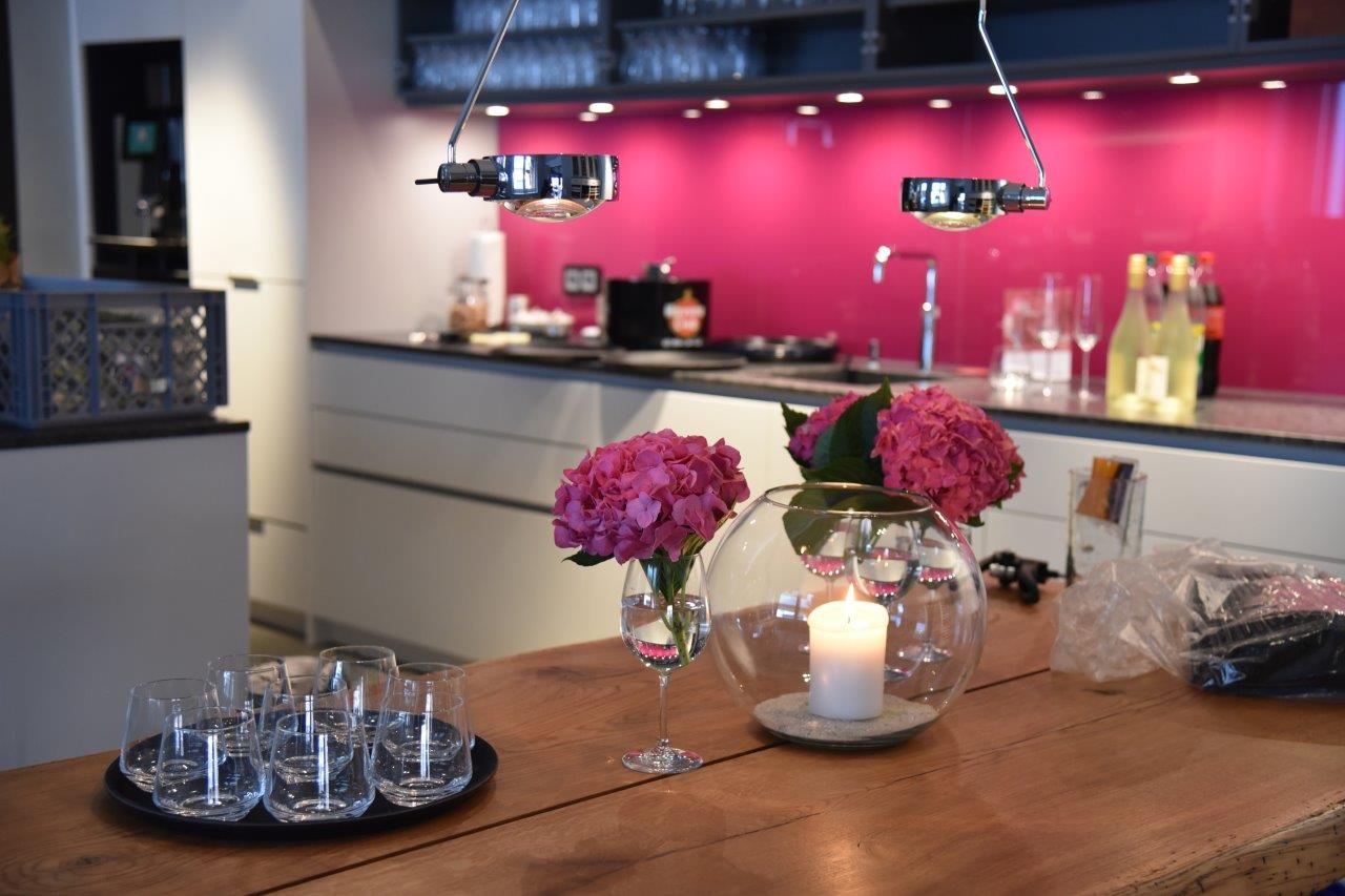 <img src=”Tisch-und-Küche-in-Küchenstudio.jpg” alt=”gedeckter Tisch und Küche in Küchenstudio”>