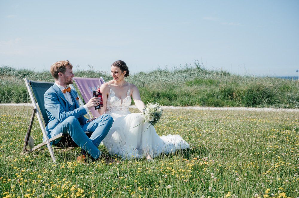 Brautpaar in Liegestühlen bei einer Strandhochzeit in Stein