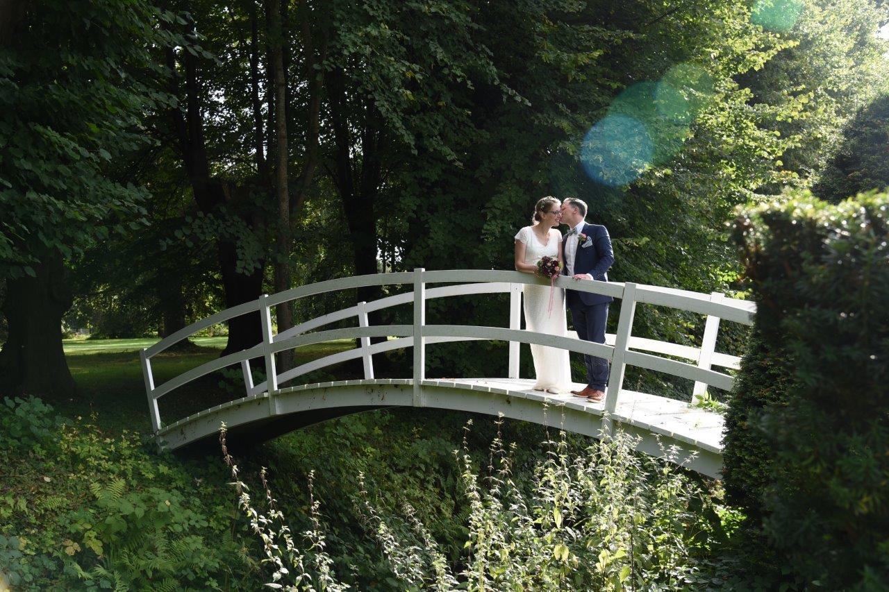 <img src=”Hochzeitsfotograf-Kiel-Brautpaar-auf-weißer-Brücke.jpg” alt=”Paar steht auf weißer Brücke und schaut sich an”>