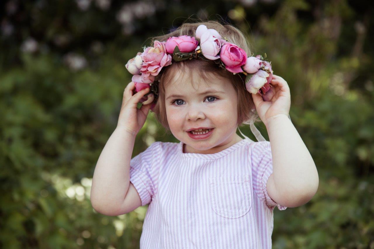 Portrait von kleinem Mädchen mit Blumenkranz