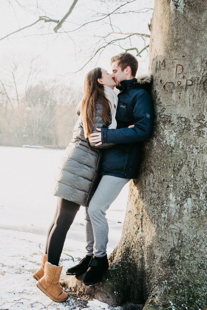 verliebtes Paar küssend an Baum gelehnt