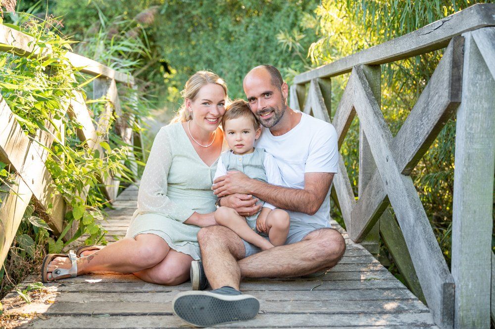 Familienfotos in Kiel, Familie sitzt auf einem Steg