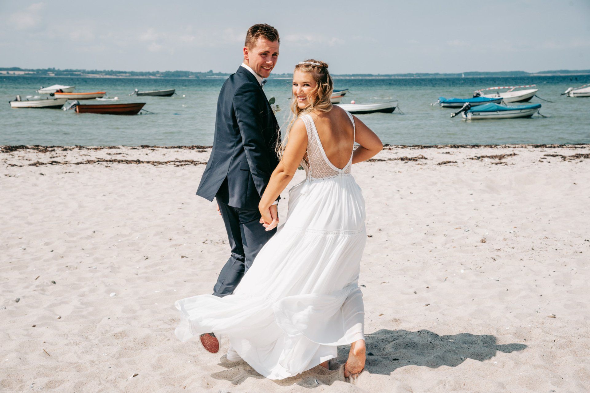 Brautpaar schaut sich nach hinten um am Strand