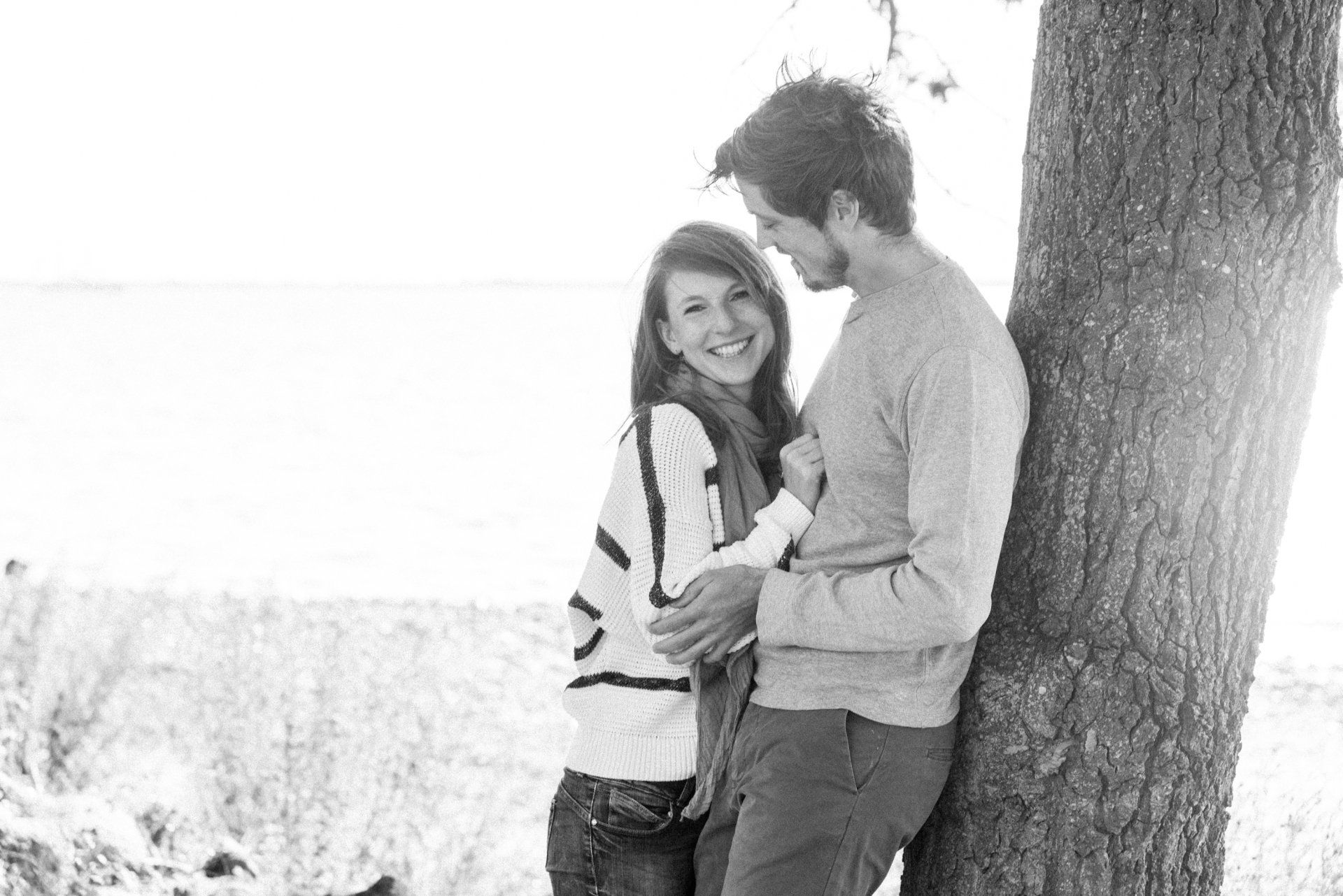 <img src=”Paar-steht-an-einen-Baum-gelehnt.jpg” alt=”Ein Paar lehnt an einem Baum, sie lacht”>