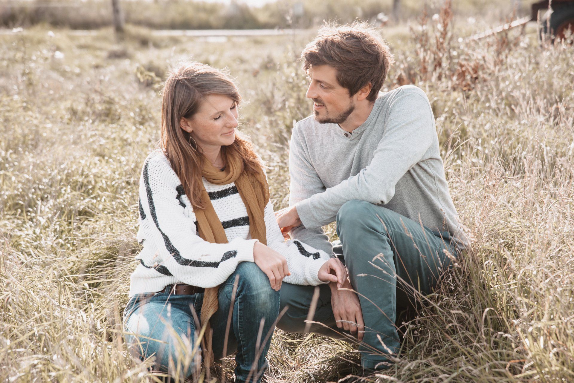 <img src=”Paar-hockt-i-hohen-Gras-aur-einer-auf-Wiese.jpg” alt=”Ein Paar hockt in hohen Gras auf einer Wiese”>