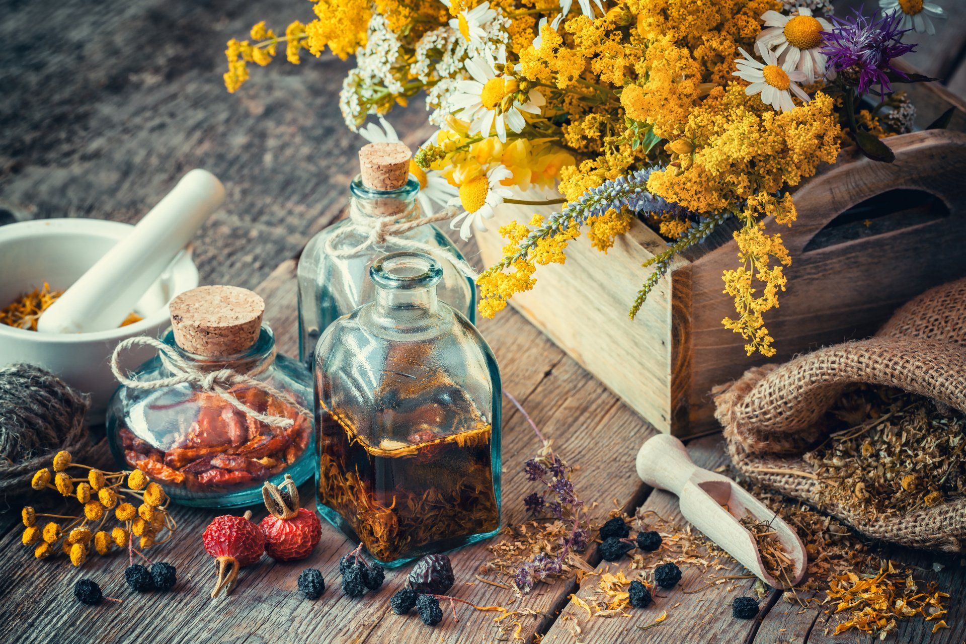 Fleurs, fioles, mortier, baies sèches, sac de graines sèchées