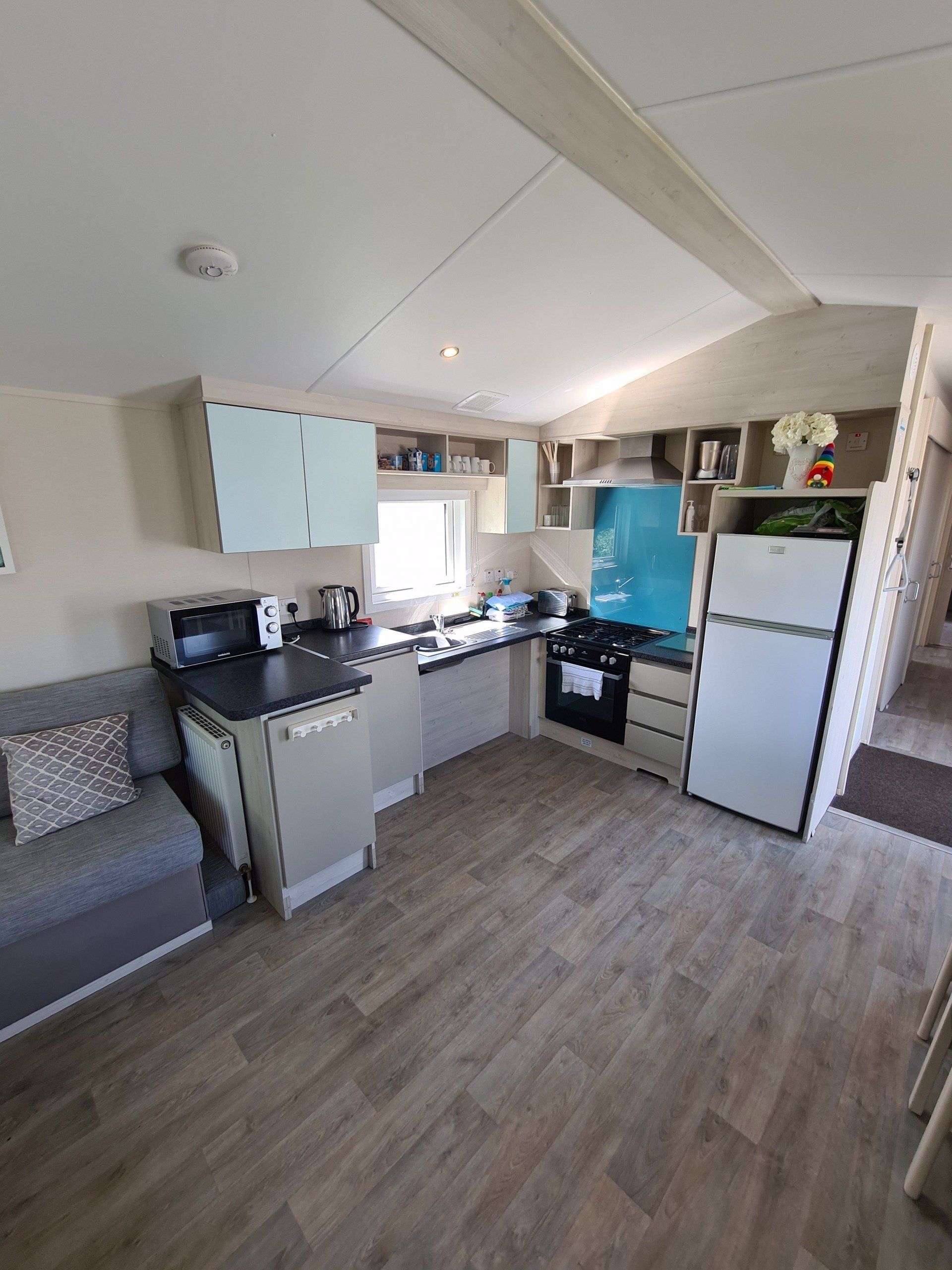 a view of the lowered kitchen from the living room of the sign along with us foundation caravan showing a fridge on the right hand side