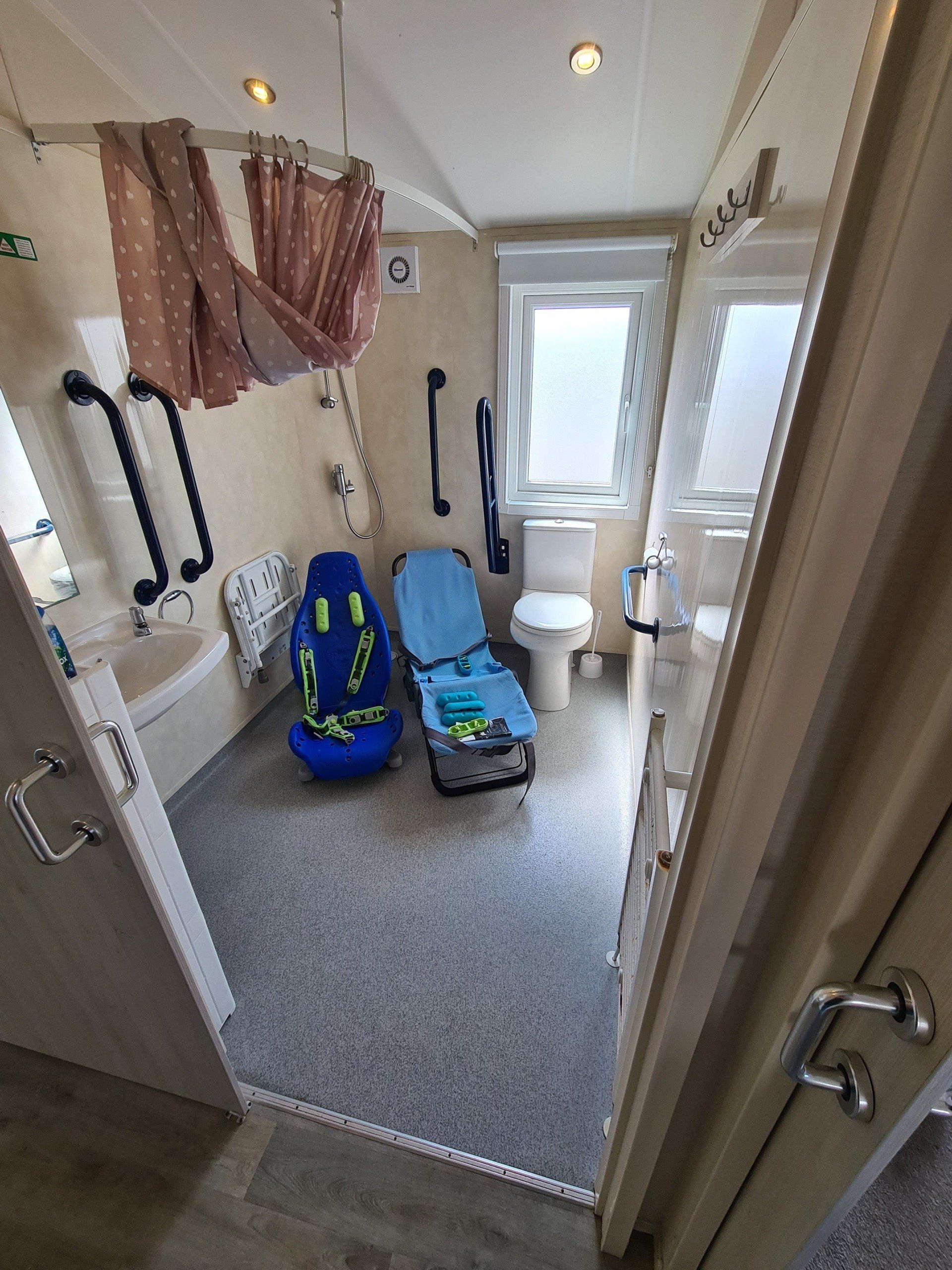 a view of the wetroom showing the two childrens shower seats