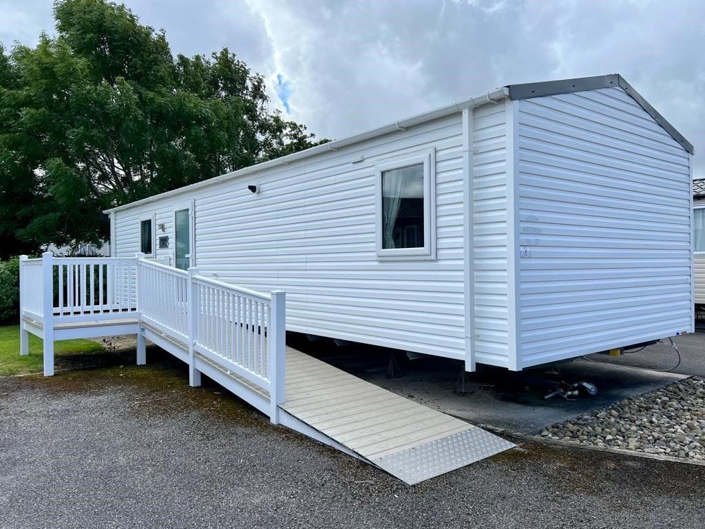 an image of the sign along with us foundations caravan on the cala gran holiday park. there is a ramp alongside the white coloured caravan leading to the door and small patio area