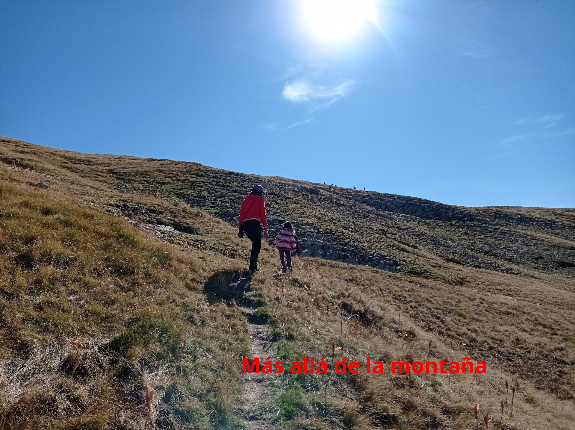 una senda marcada que nos lleva bordeando la cima a través de un verde pastizal