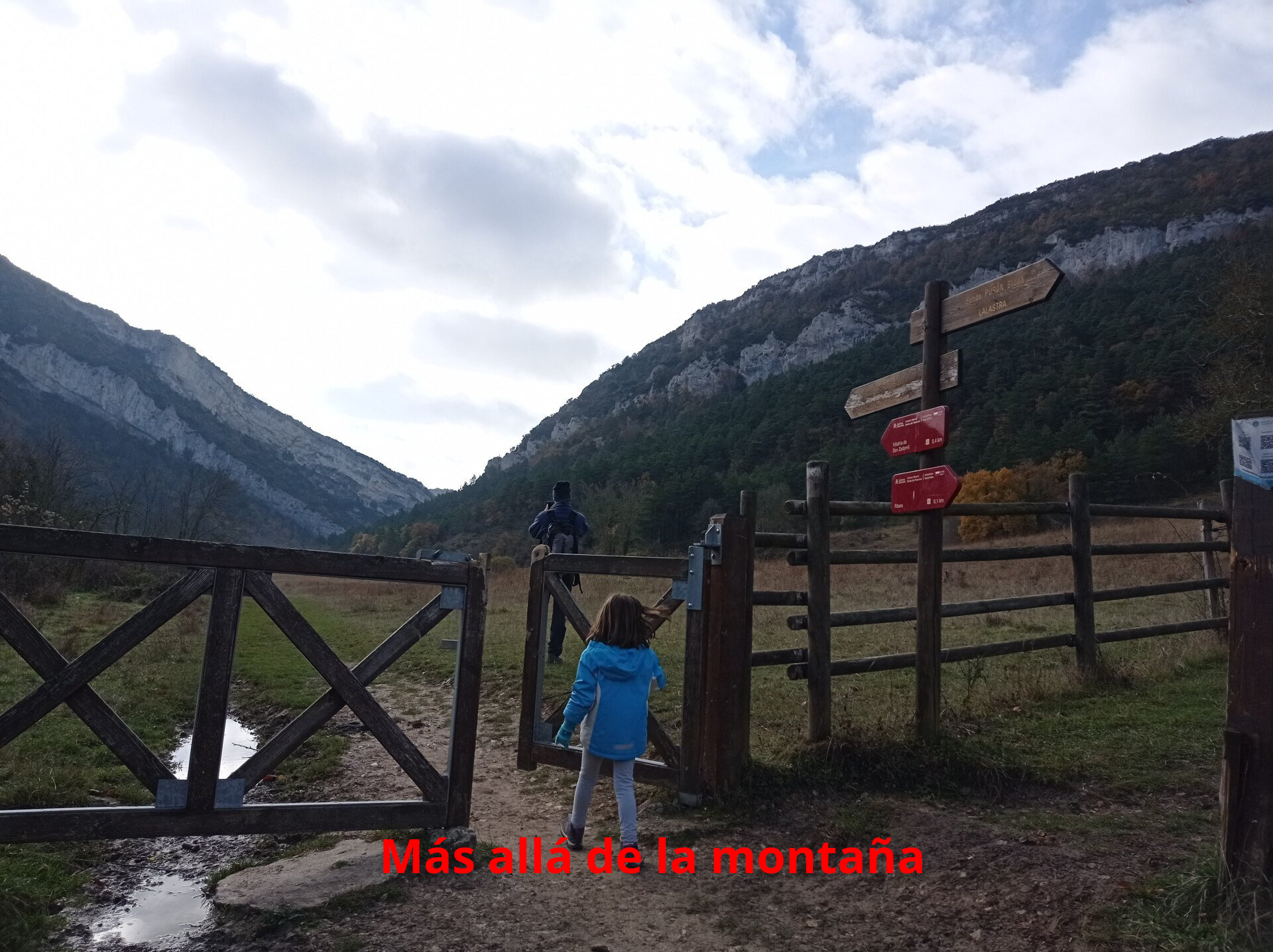 En este punto pasamos por una puerta de madera y seguimos el camino que cruzaba un amplio prado verde