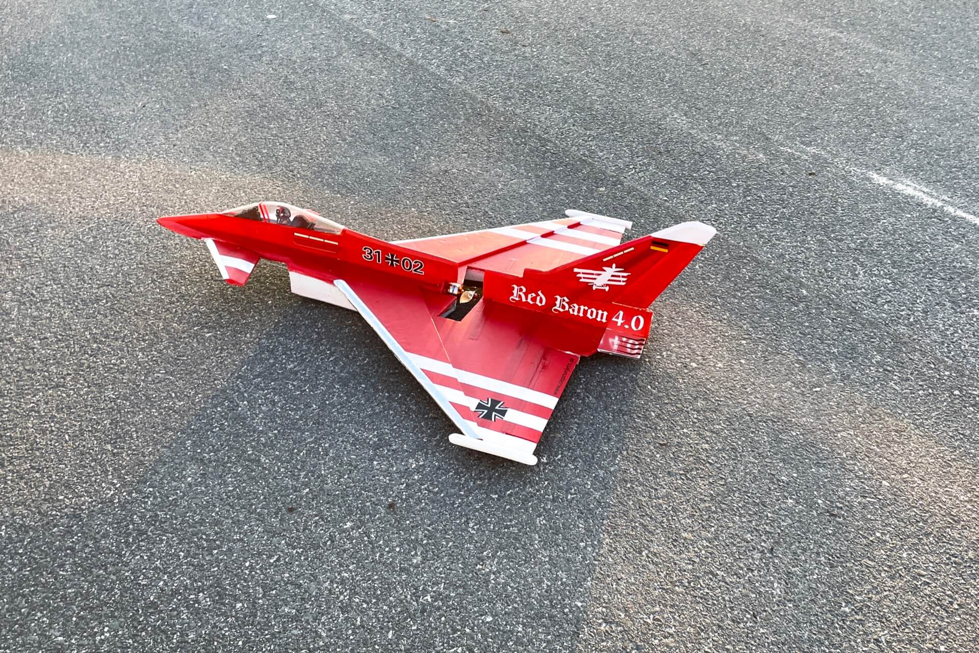 Roter Modell Eurofighter auf Asphalt für den Start.