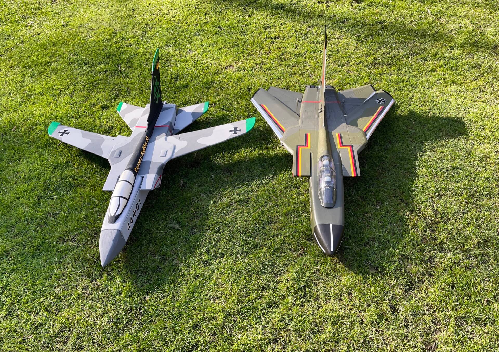 Treffen der Generationen: Mein erster Tornado aus 2020 und mein eigenes Projekt aus 2022. Fliegen tun sie beide. Zwei Torandos aus Depron nebeneinander auf der Wiese.