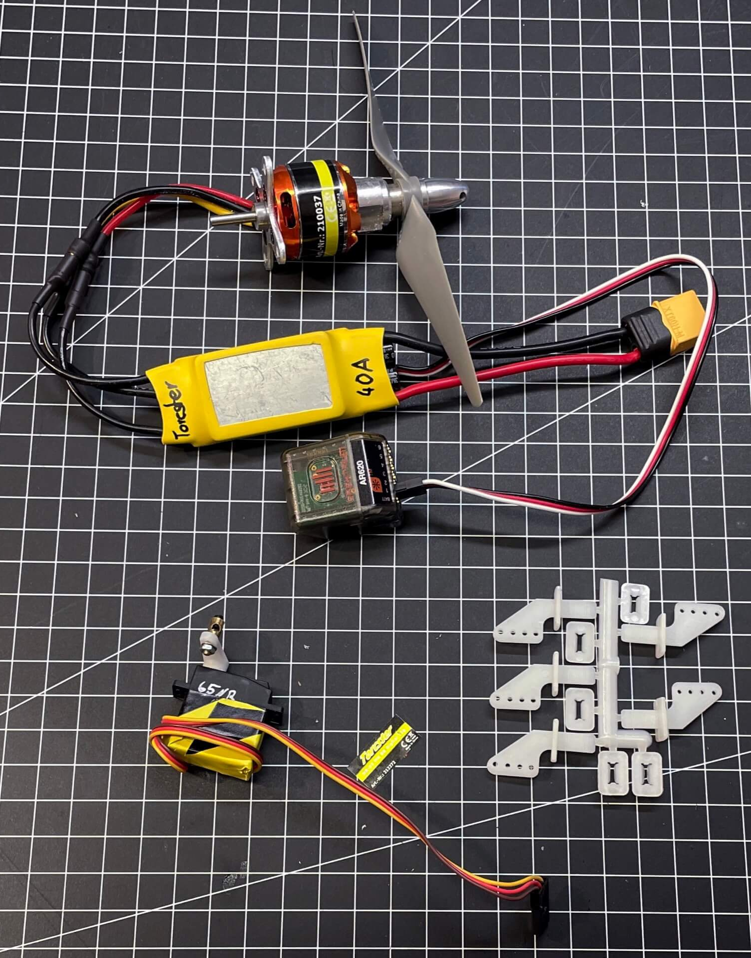 Alle Komponenten, die es zum Betrieb eines Modellflugzeugs (nicht nur Depronjets) benötigt. Auch abgebildet: Die Ruderhörner der Firma Arkai und ein Spektrum AR620 Empfänger. Antrieb und elektronische Komponenten