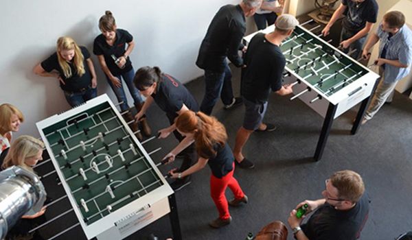 2 weiße Kickertische von White Kicker bei einem -Mitarbeiter-Event in Hamburg.  Alle haben viel Spaß.