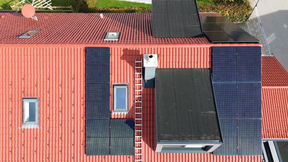 Rotes Hausdach, dass eine installierte Photovoltaik-Anlage (PV-Anlage) zeigt