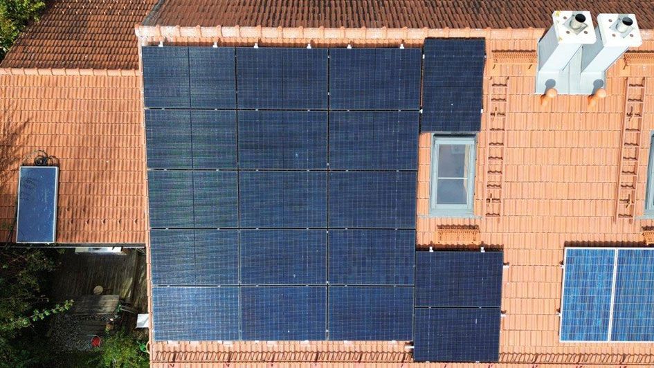 Rotes Hausdach, dass eine installierte Photovoltaik-Anlage (PV-Anlage) zeigt