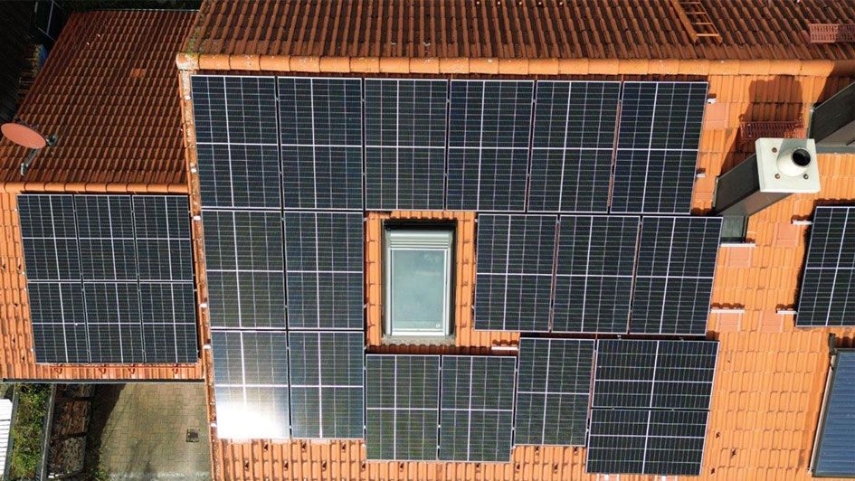 Rotes Hausdach, dass eine installierte Photovoltaik-Anlage (PV-Anlage) zeigt