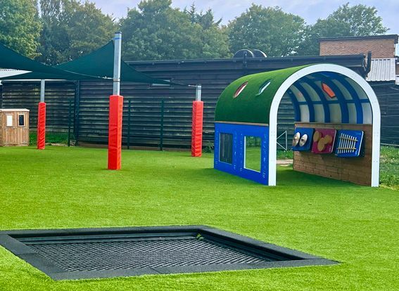 Playground area with green grass and play equipment