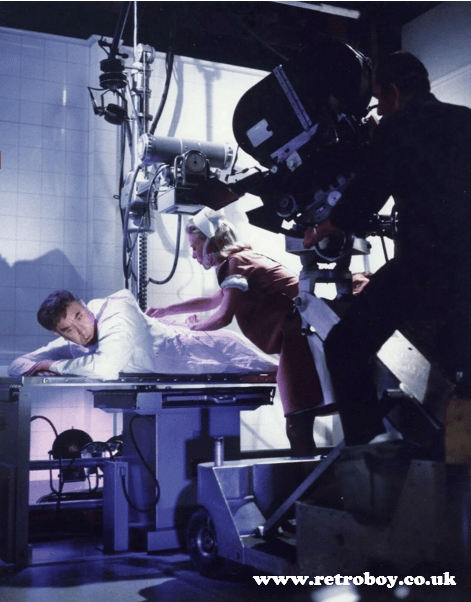 Frankie Howerd being 'nursed' by Valerie Van Ost in a behind the scenes shot from 'Carry On Doctor' (1967).