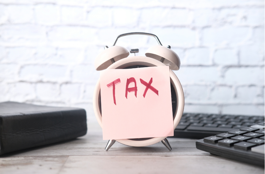 Alarm clock with Tax post it note stuck on