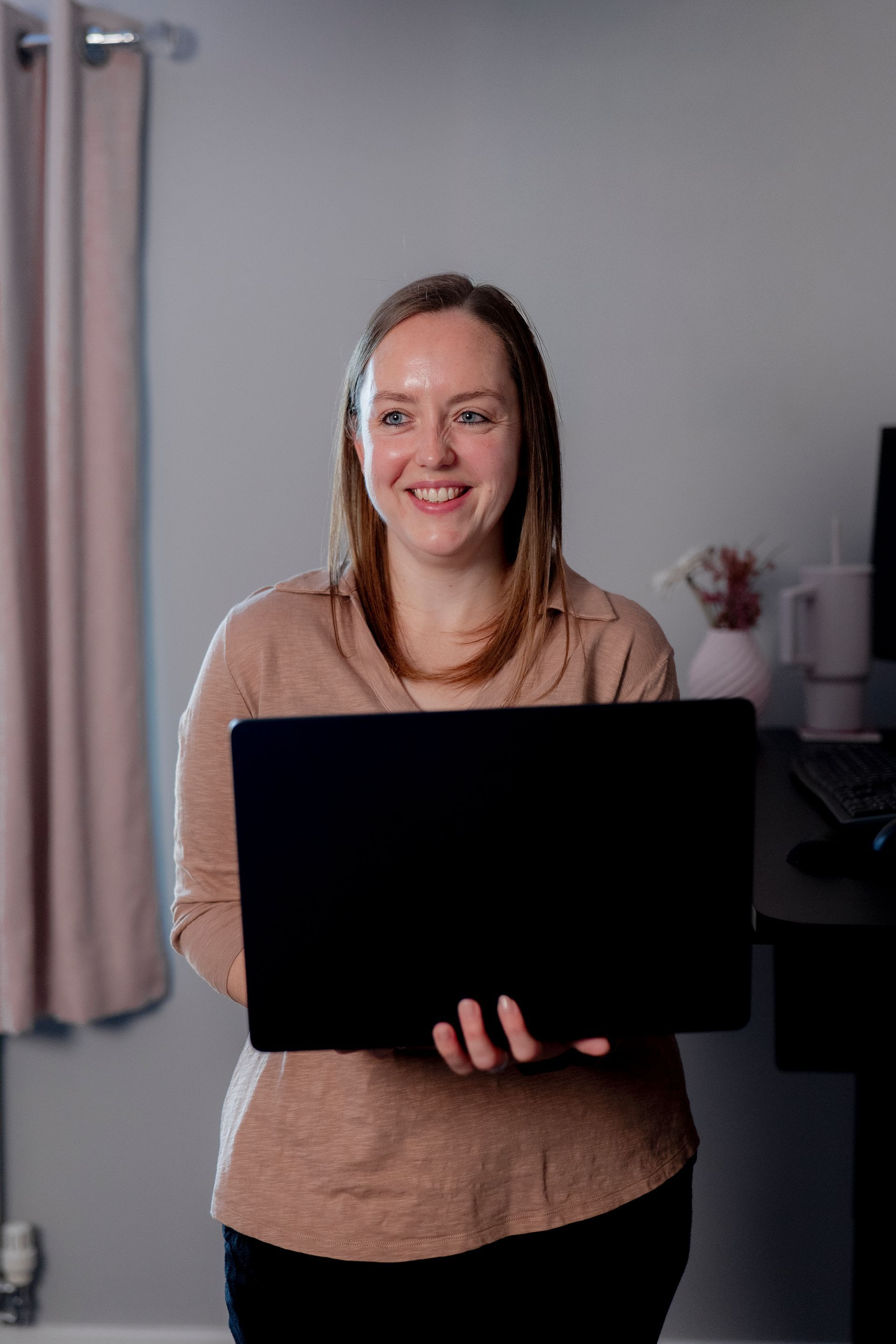 Chrissy standing with a laptop