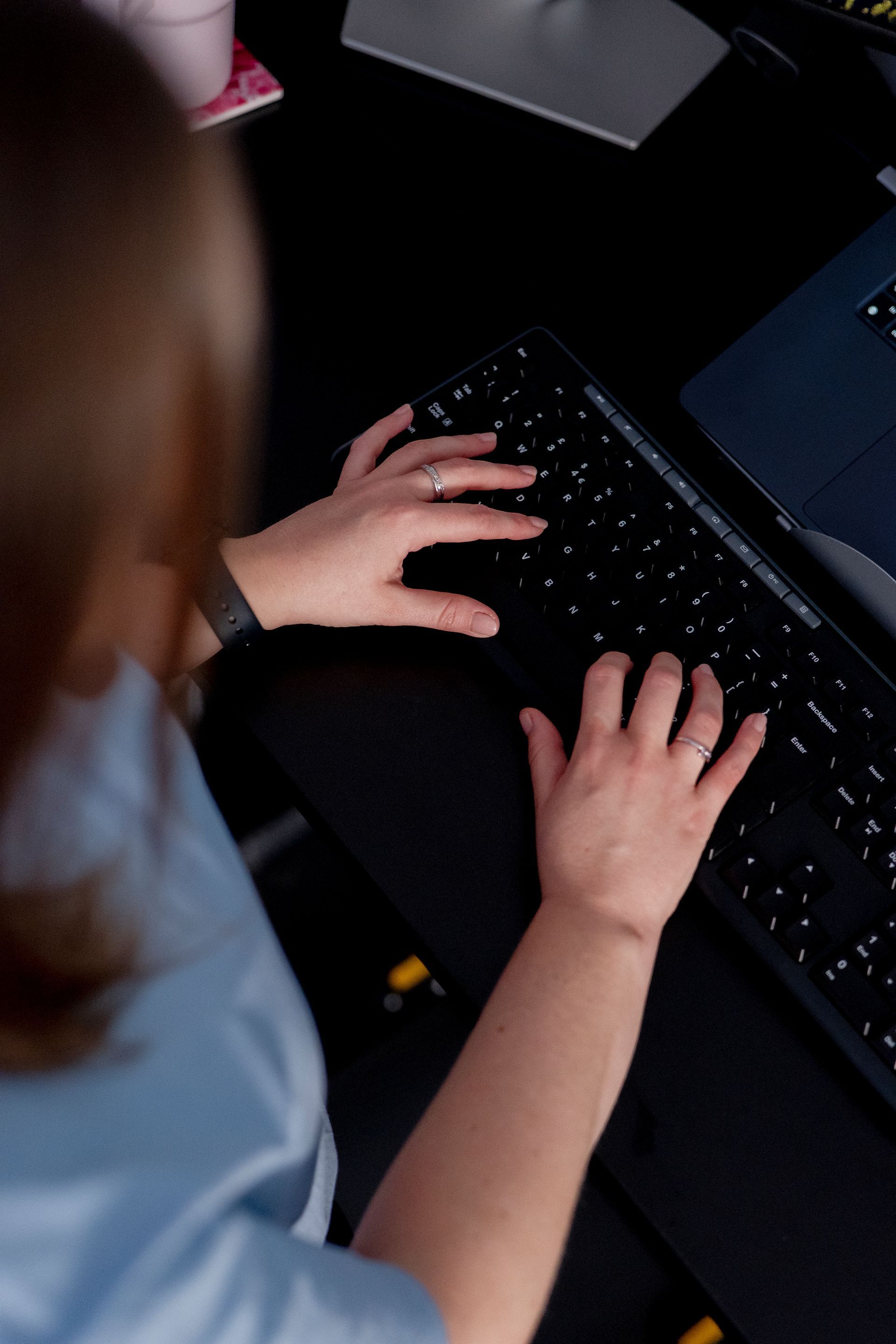 View of woman working at a laptop on a desk from above