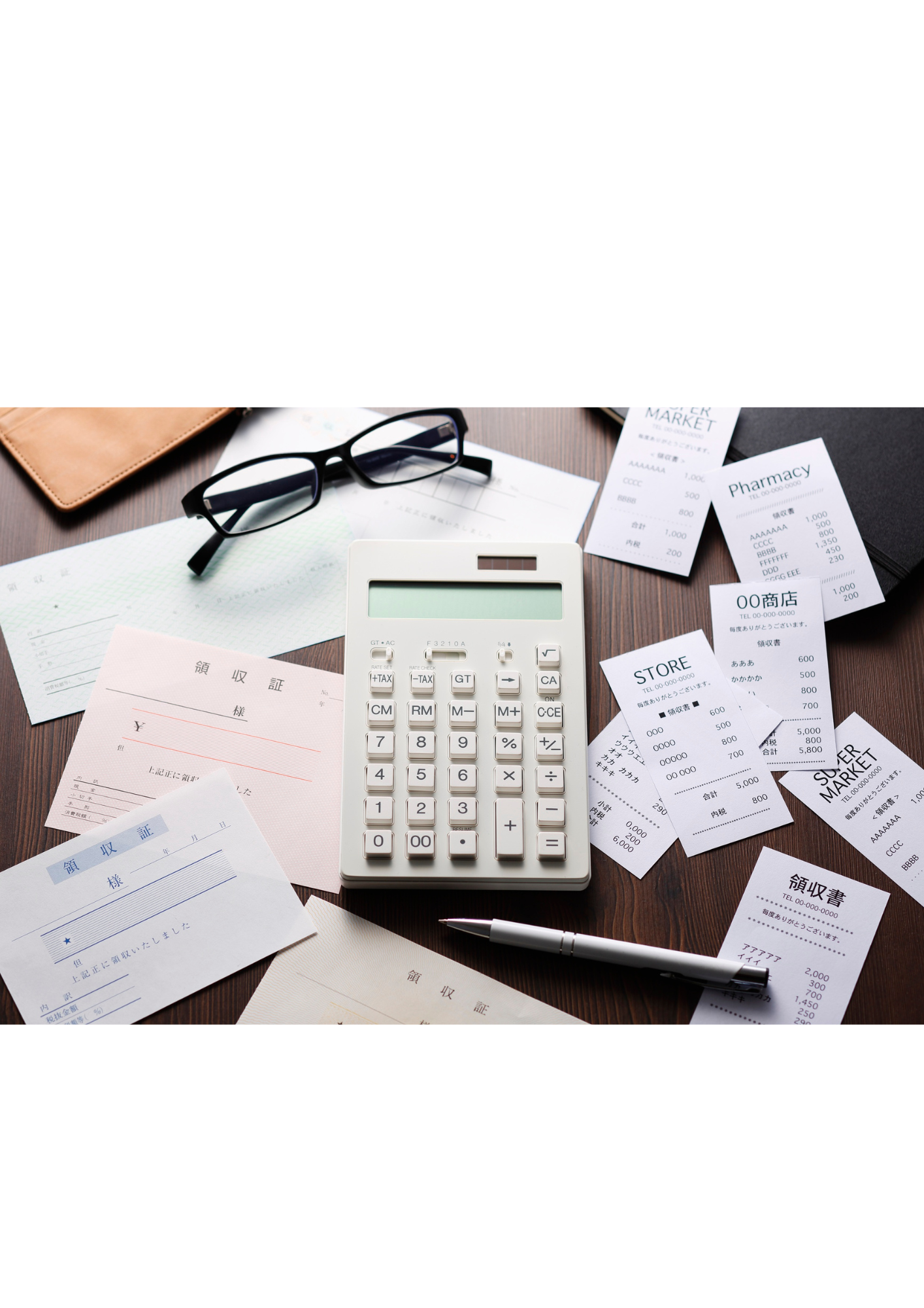 Calculator surrounded by paperwork and receipts.