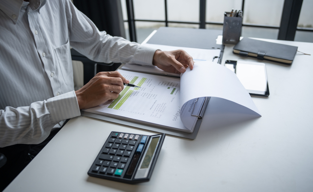 Business person at a desk with calculator and figures