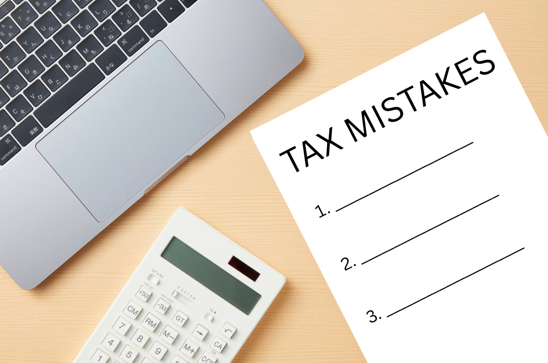 Desk with laptop, calculator and paper with tax mistakes on