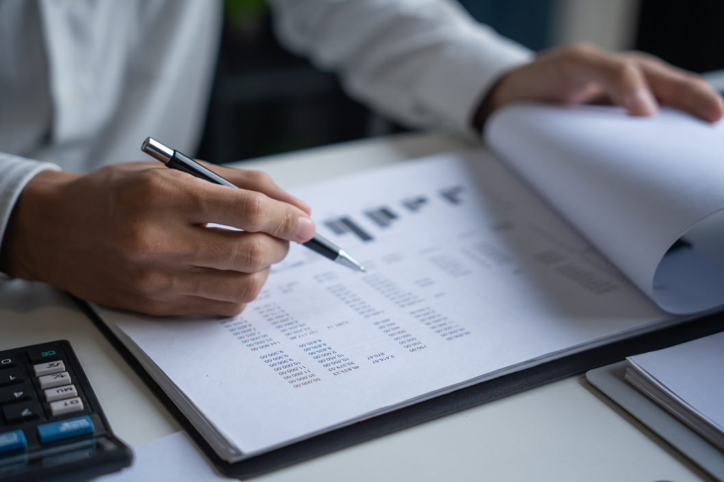 Person at a desk with figures and a pen, and a calculator