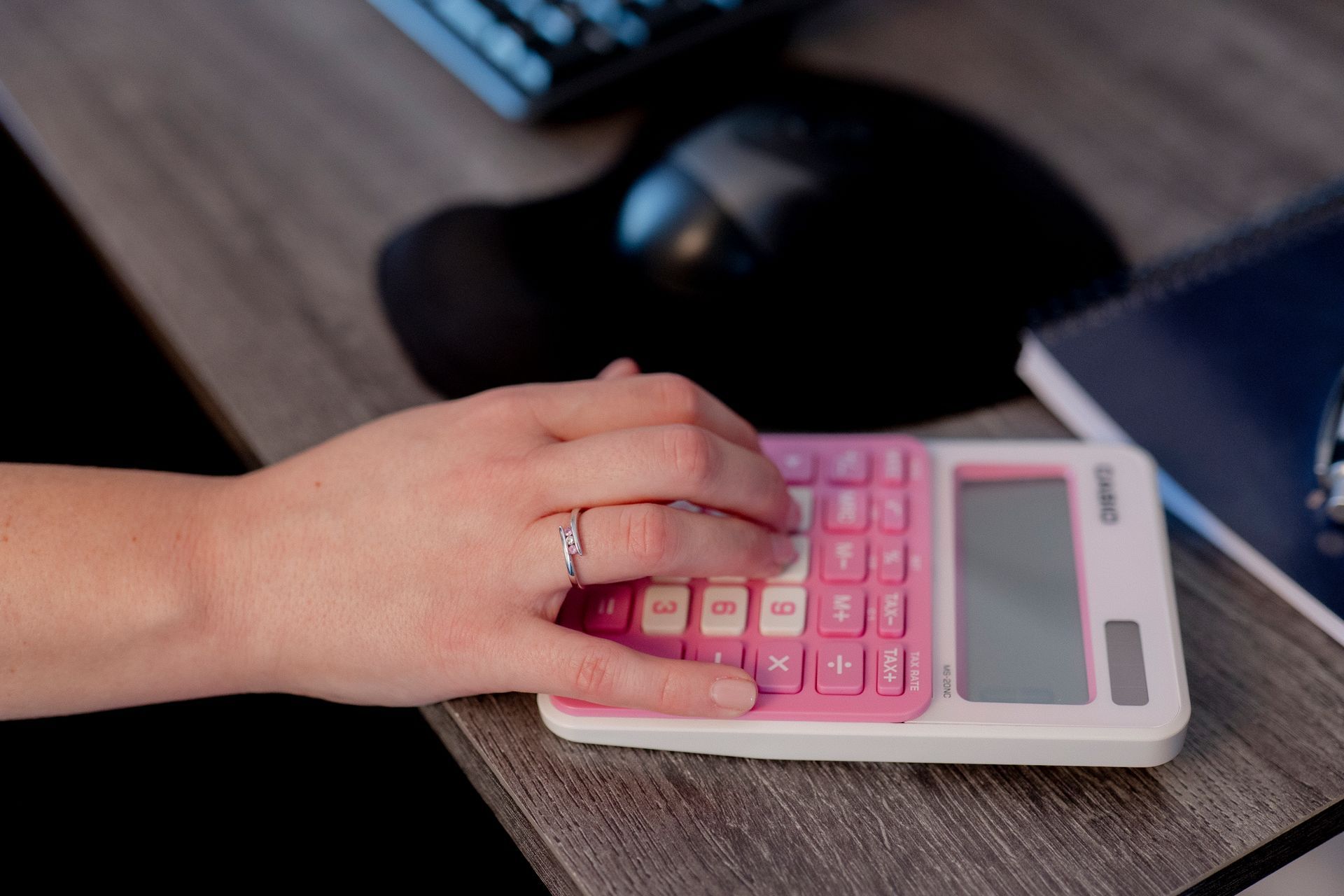 Hand working on pink calculator