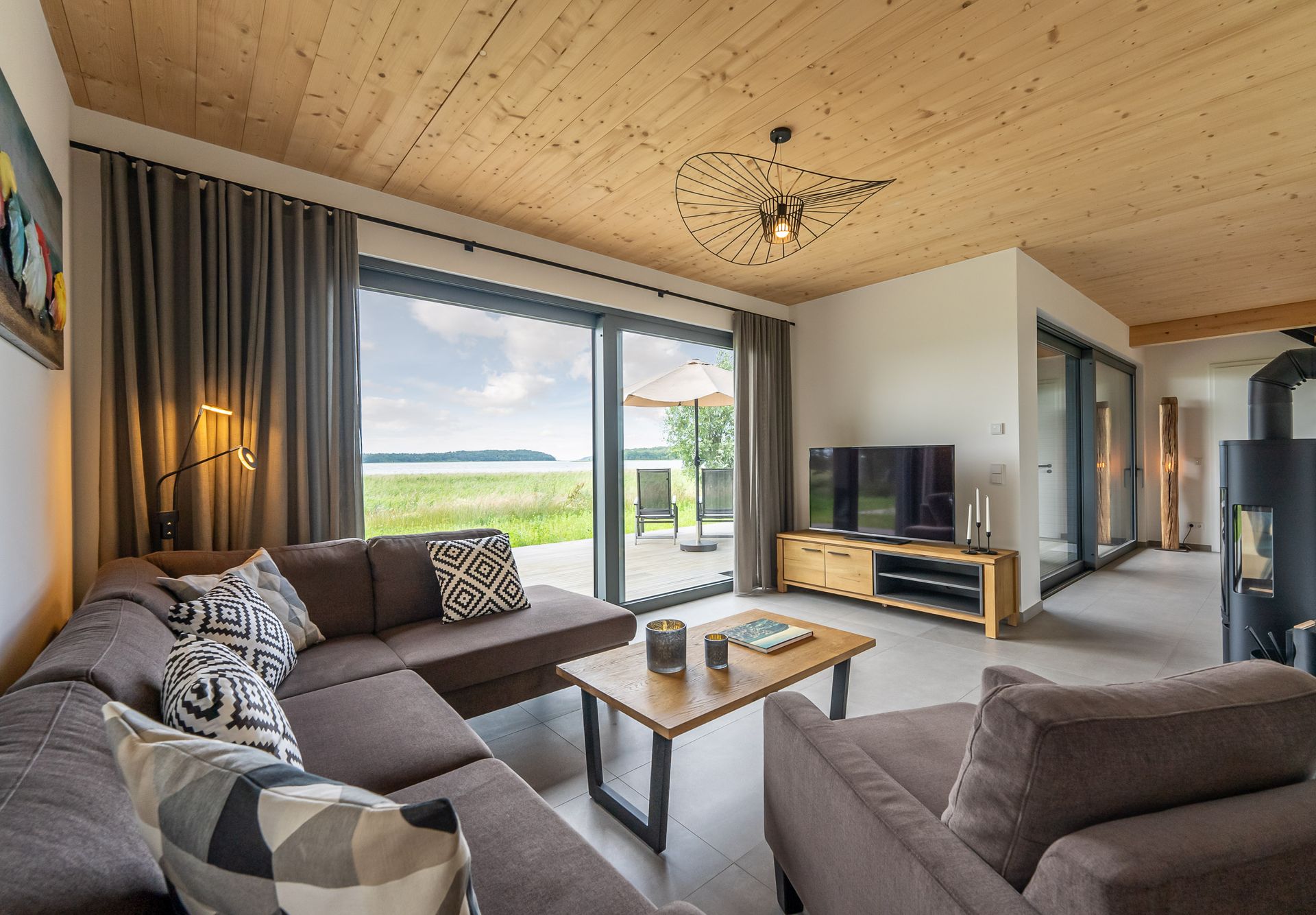 Wohnzimmer mit Kamin und bodentiefen Fenstern