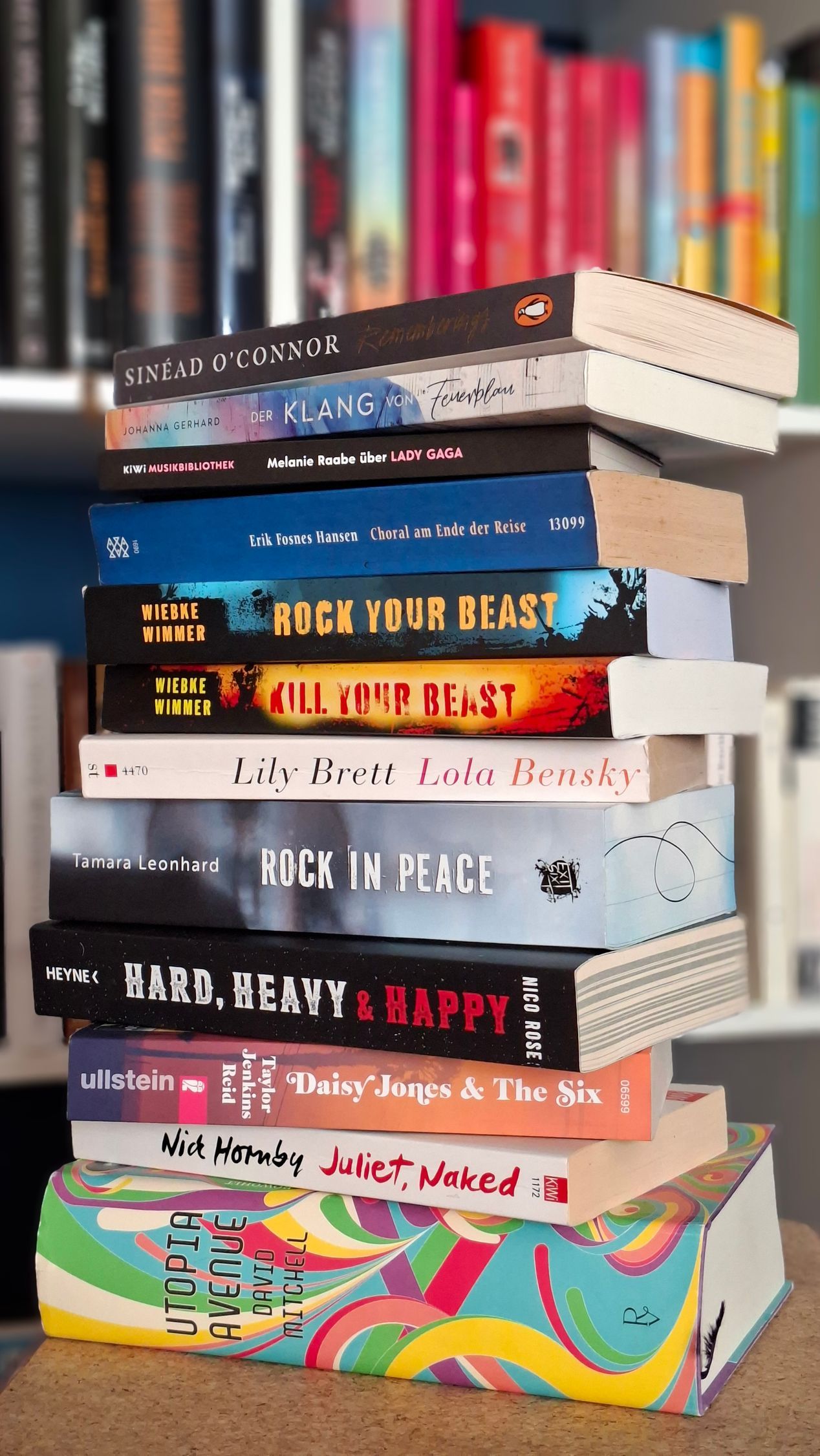 Ein Stapel Bücher über Musik für die Buchempfehlungen vor einem Bücherregal
