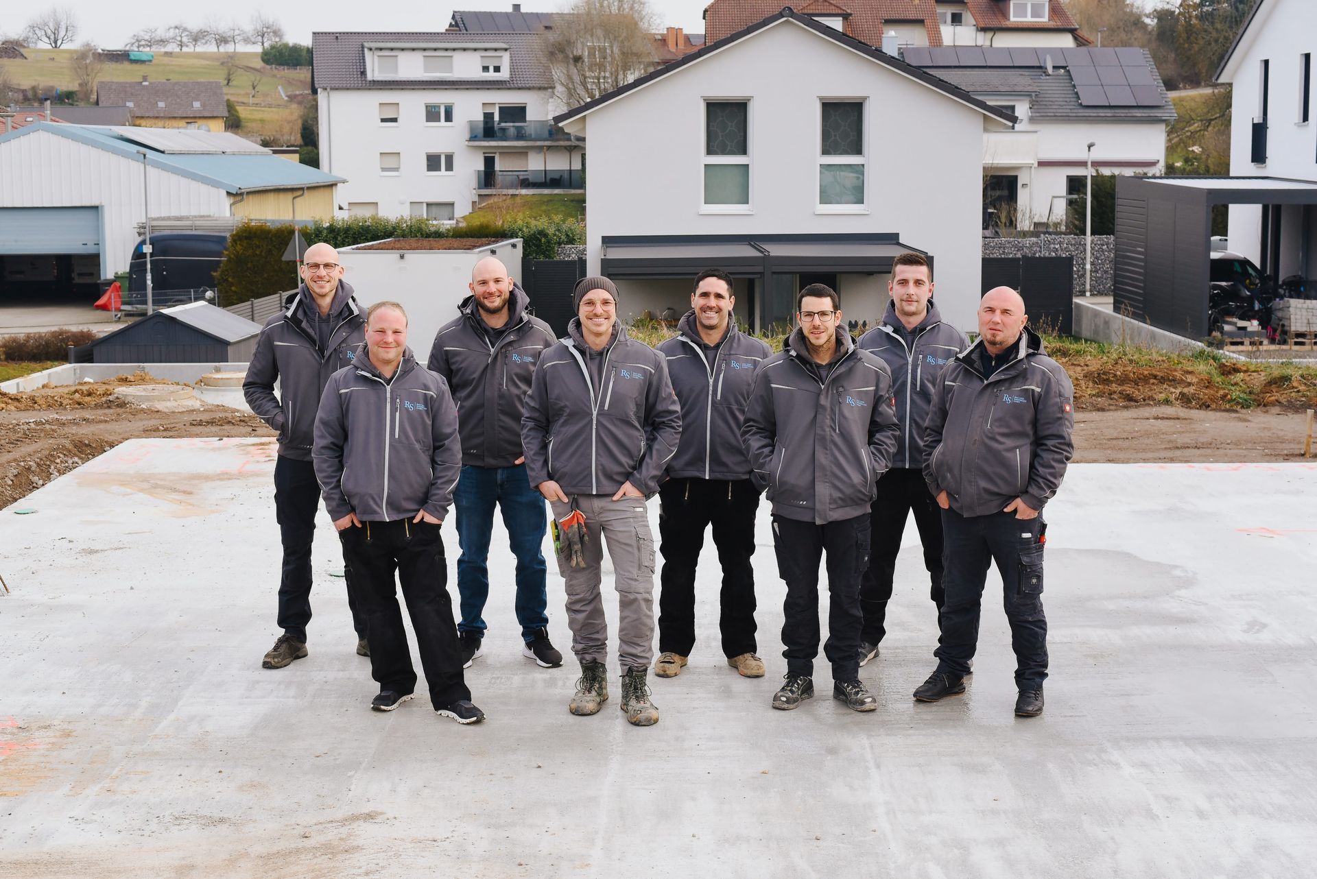 Das Team der RS Elektro. Acht Männer auf einer Baustelle.