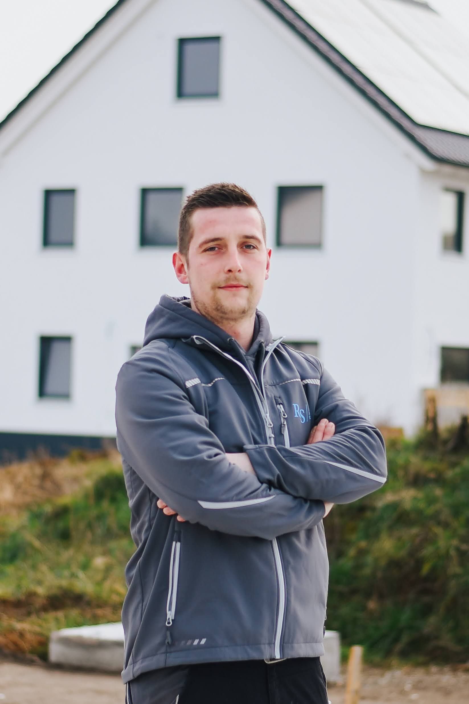 wei Bauarbeiter der RS Bau & Immo GmbH stehen auf einer Baustelle.