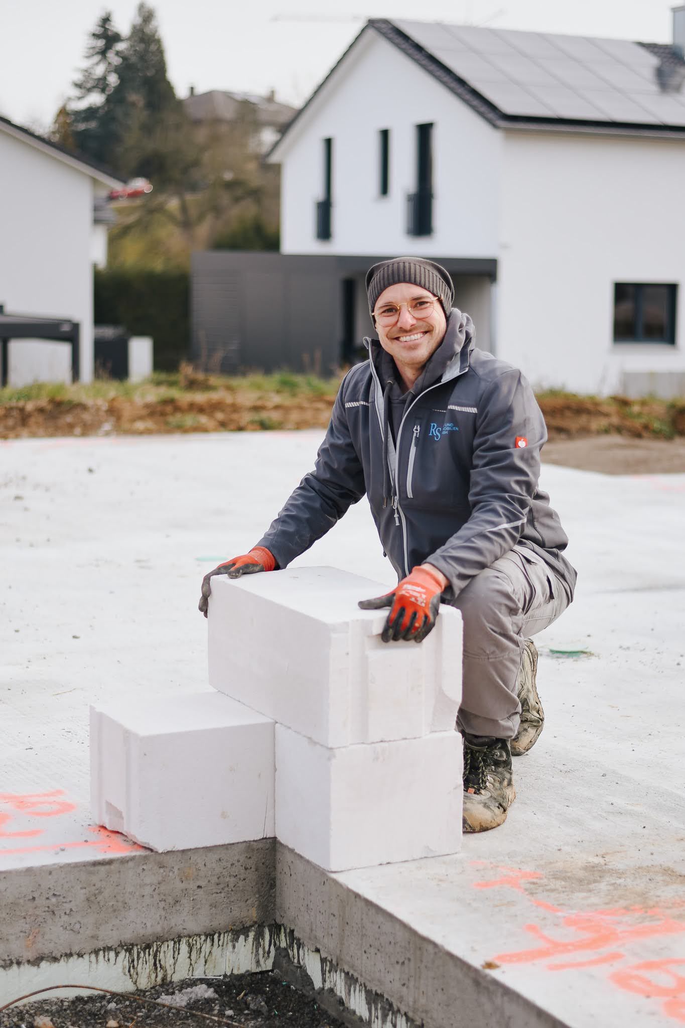 Bauarbeiter der RS Bau & Immobilien GmbH stehen auf einer Baustelle.