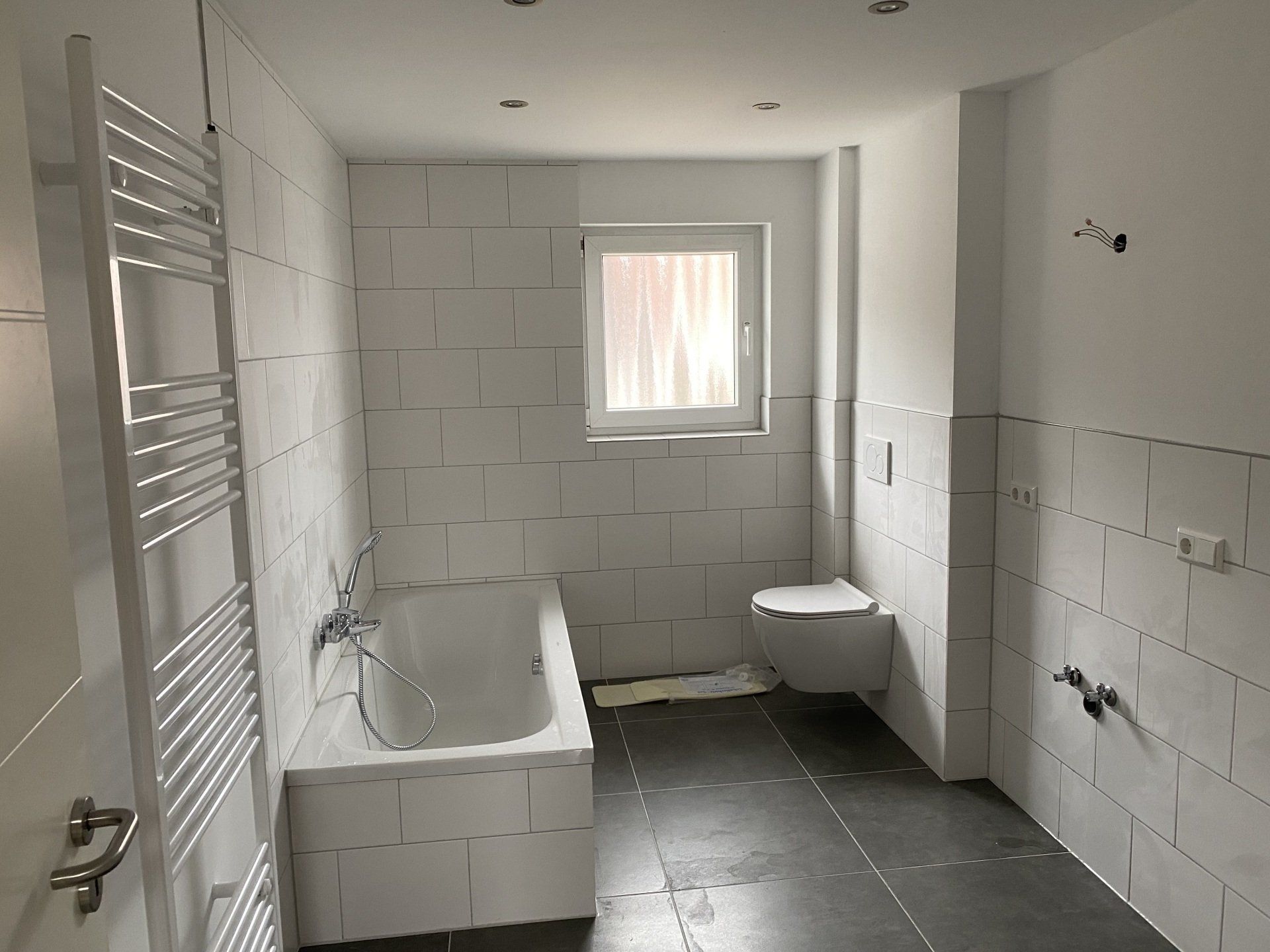 Modernisiertes Badezimmer mit Badewanne und Fliesenboden in Helmstadt – Badsanierung durch RS Bau & Immobilien.