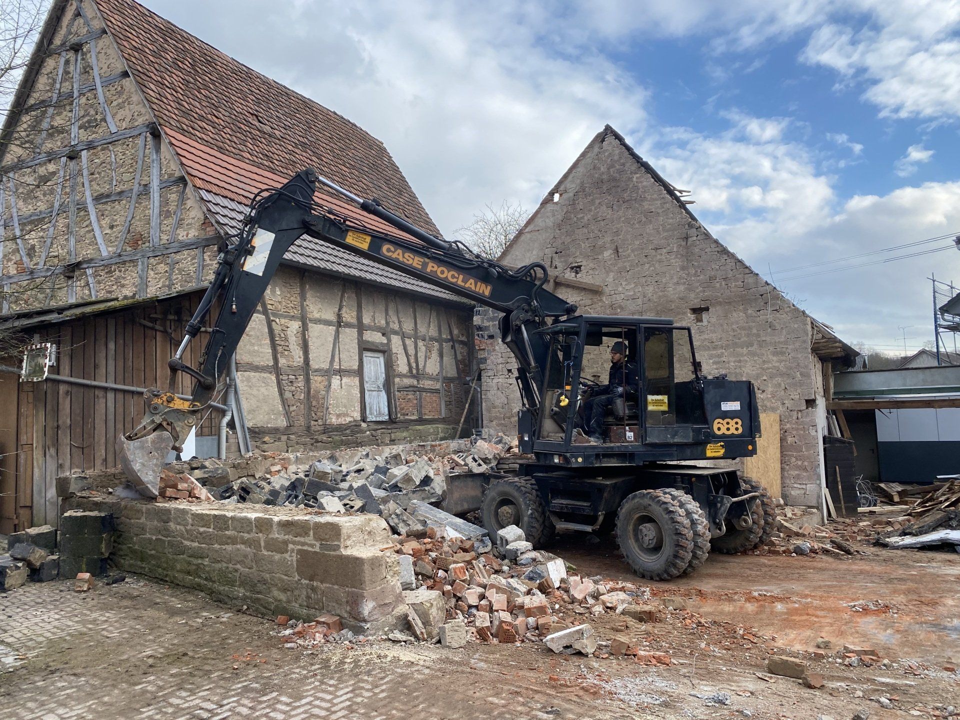 Bagger bei Abrissarbeiten an einem alten Fachwerkgebäude in Helmstadt – Erdbau und Rückbau durch RS Bau und Immobilien.