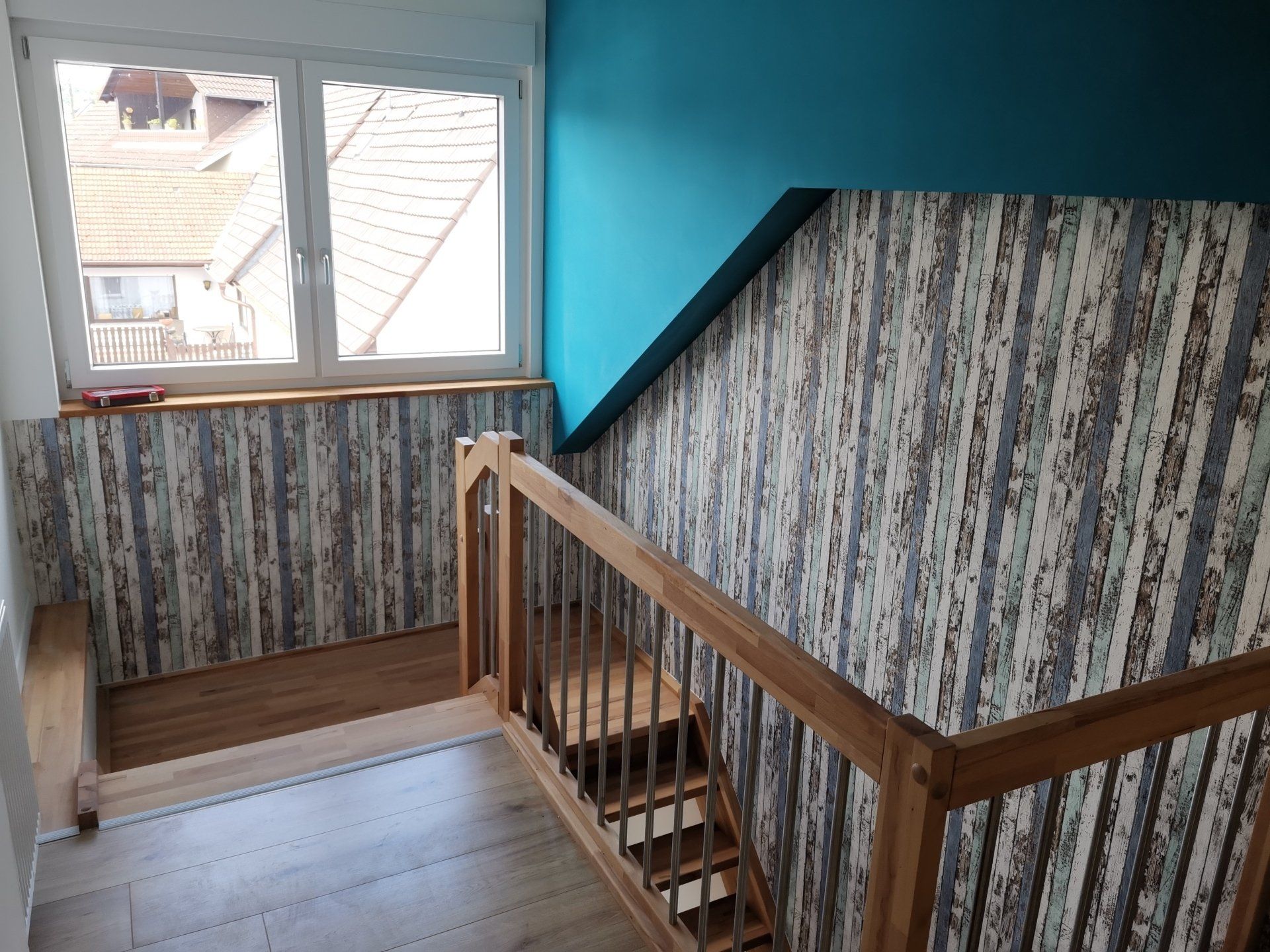 Renoviertes Treppenhaus mit Holzgeländer und moderner Wandverkleidung in Helmstadt – Innenausbau von RS Bau & Immobilien.
