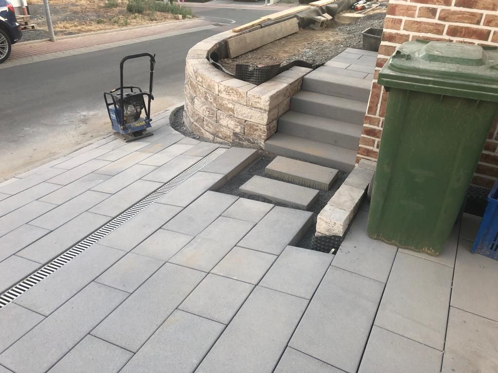 Gepflasterte Einfahrt mit Treppenanlage und Entwässerungssystem in Helmstadt – Außenarbeiten von RS Bau & Immobilien.