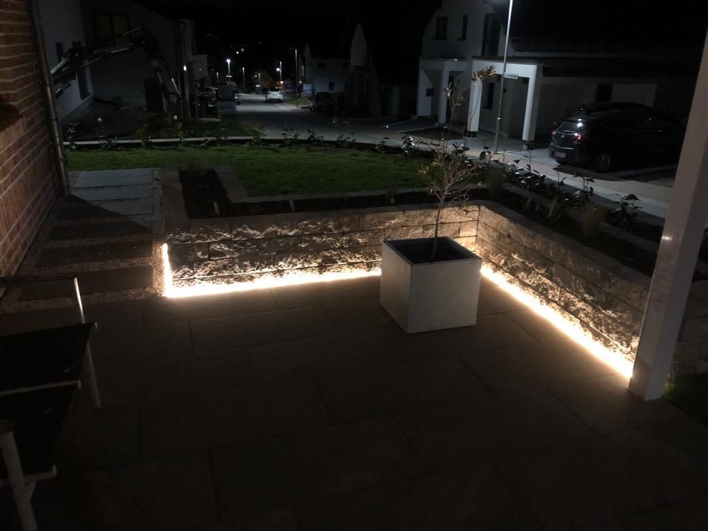 Beleuchtete Terrasse mit Natursteinmauer und indirekter LED-Beleuchtung in Mosbach – Außenbereich von RS Bau & Immobilien.