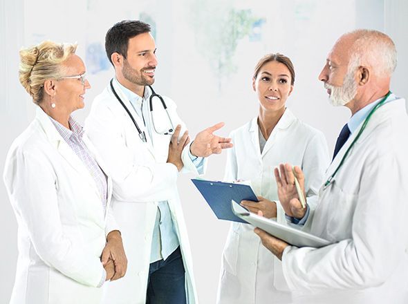 Team von Ärztinnen und Ärzten verschiedenen Alters im Dialog