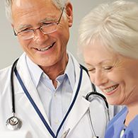 Praxisabgabe - Älterer Arzt und ältere Ärztin freuen sich