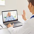 Digitale Praxis - Videosprechstunde einer Ärztin mit älterem Patienten