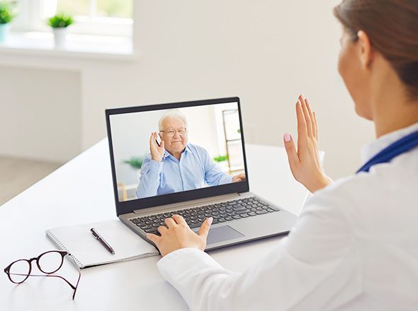 Digitale Praxis - Videosprechstunde einer Ärztin mit älterem Patienten