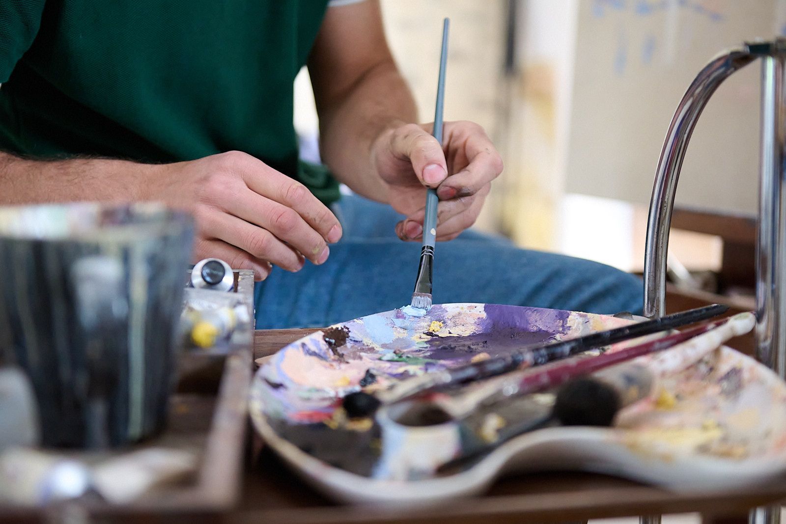 Mains de peintre préparant sa palette de couleurs