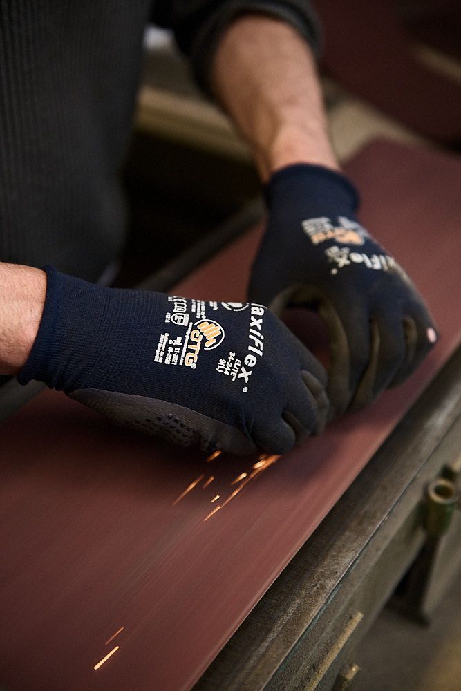 Artisan travaillant à la meule avec étincelles