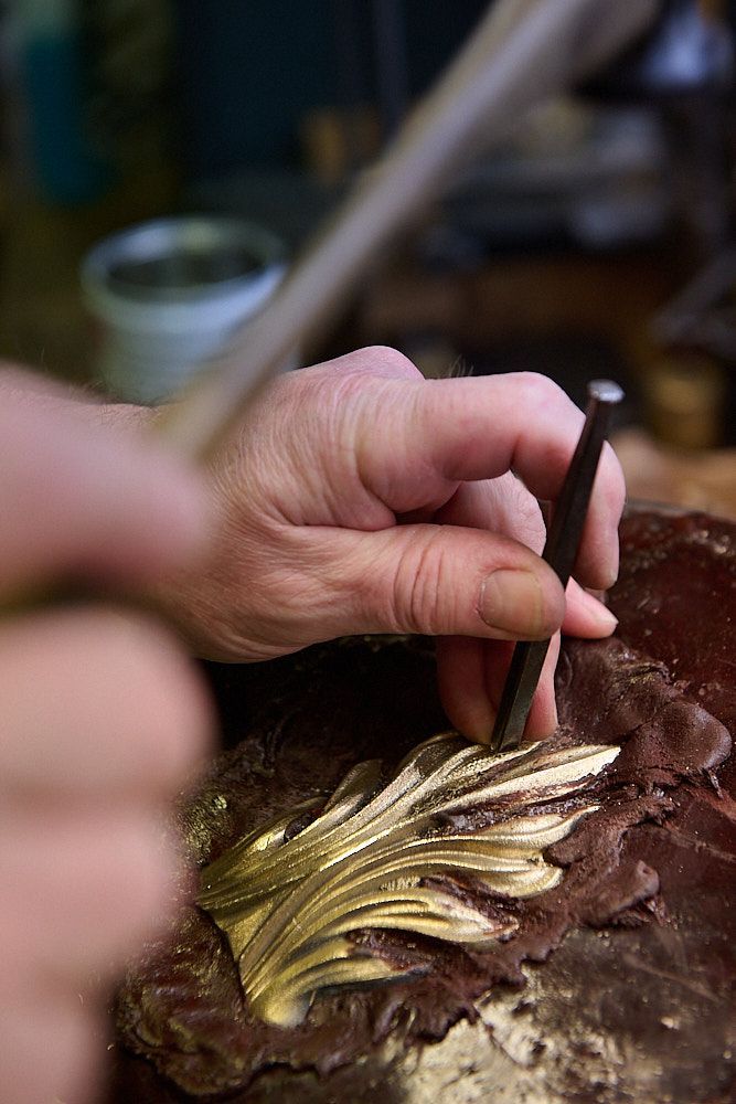 Main d'artisan cisaillant du bronze